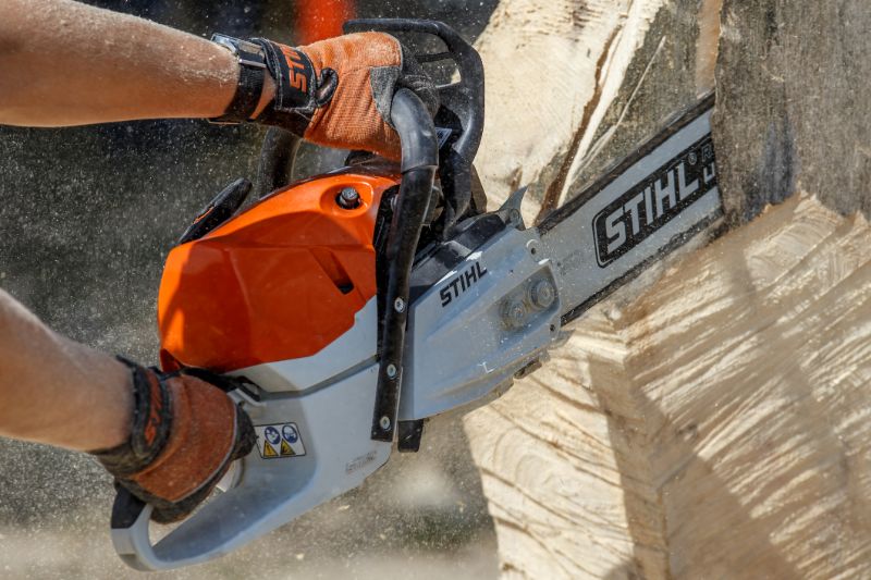 Stihl-chainsaw-cutting-with-two-hands-min