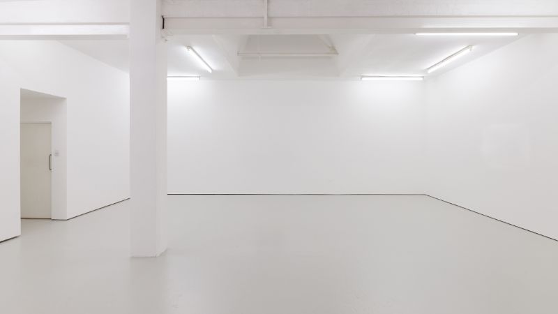 concrete-mixers-a-view-of-a-white-painted-interior-of-an-empty-room-or-an-art-gallery-with-a-skylight-lighting-and-concrete-floors-130551981-min
