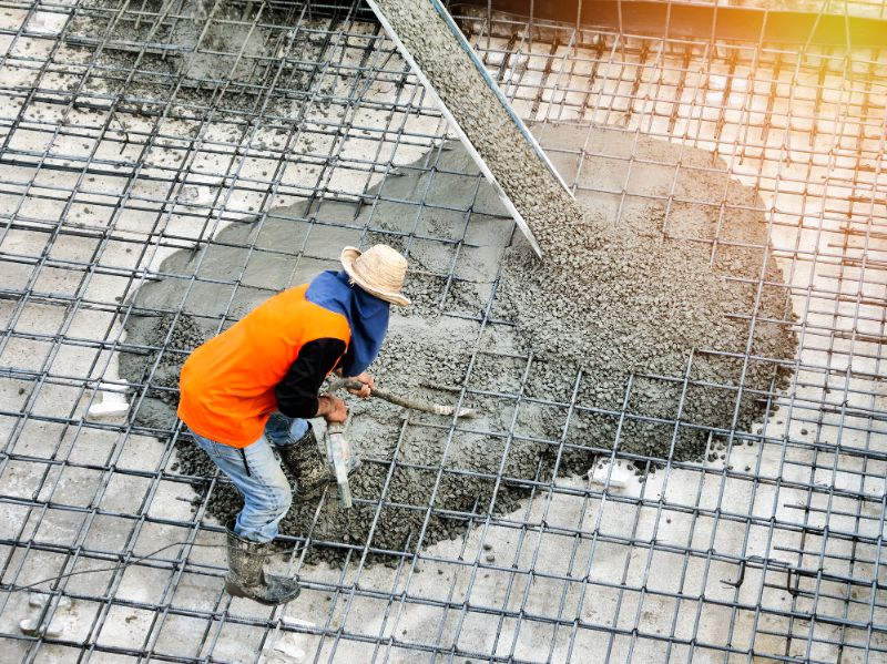 concrete-mixers-top-view-of-builders-in-orange-shirt-pouring-concrete-works-on-the-construction-site-187462813-min