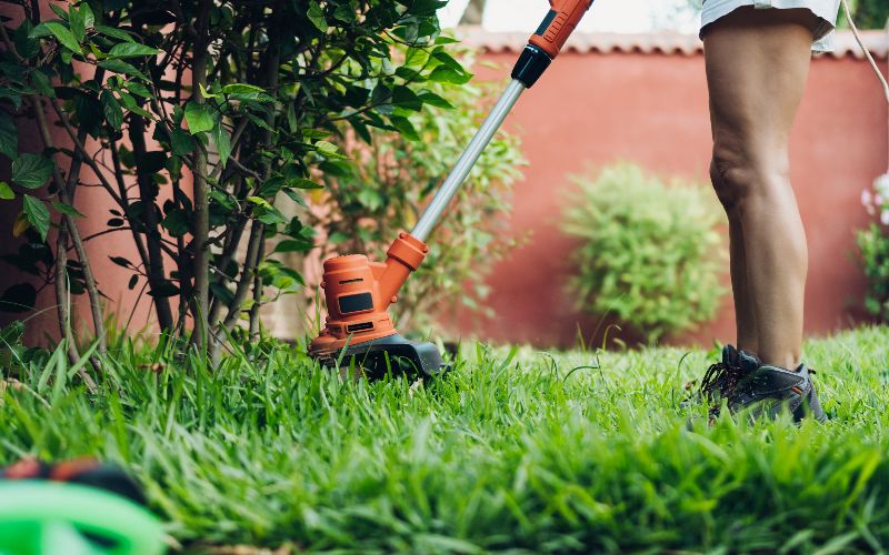 brushcutters-woman-using-the-brushcutter-cutting-the-lawn-min