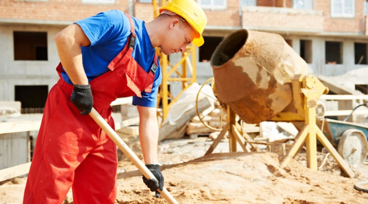 concrete-mixer for-sale-builder-worker-at-construction-site-with-shovel-min