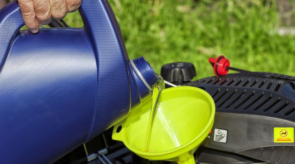 ride on mower-a-man-pours-oil-on-his-lawn-mower-min