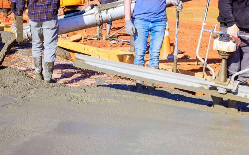 CONCRETE-MIXER-construction-workers-pour-smooth-concrete-at-building-site-during-works-day-light-hours-min