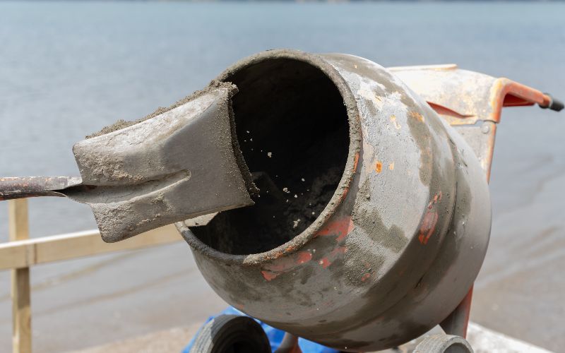 Concrete-mixer-focus-on-grit-and-sand-inside-concrete-mixer-turning-blurred-in-motion-min