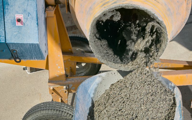 cement-mixers-concrete-mixer-pouring-wet-cement-into-wheelbarrow-min
