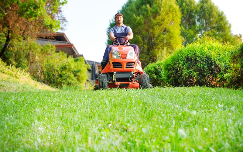 ride-on-mower-gardener-driving-a-riding-lawn-mower-in-garden-min