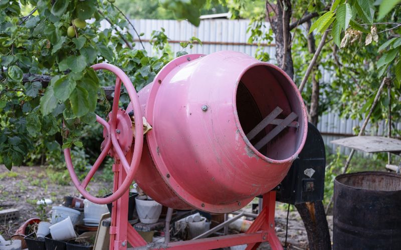 concrete-mixer-concrete-is-loaded-into-a-cart-from-a-200-liter-orange-electric-concrete-mixer-photo-taken-on-a-sunny-summer-day-outdoors-min