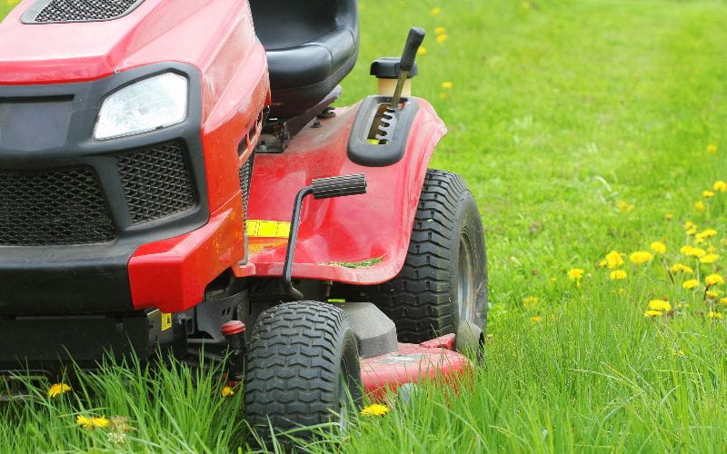ride-on-mower-mowing-or-cutting-the-long-grass-with-a-lawn-mower-gardening