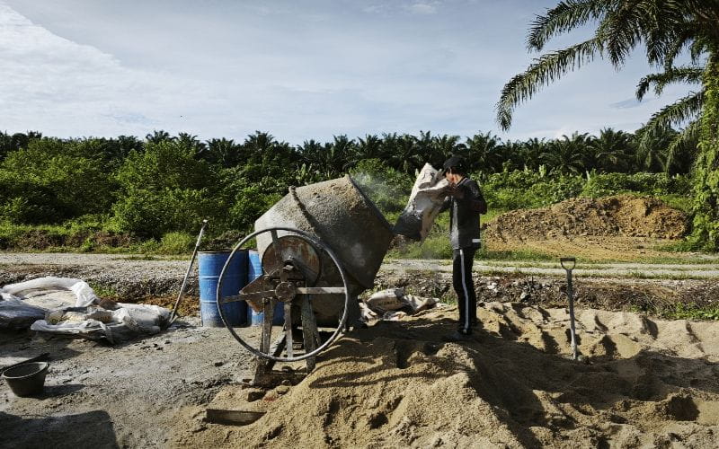 concrete-mixer-for-sale-a-laborer-working-by-the-cement-mixer-machine-near-the-pile-of-sand-and-cement-bags (1)