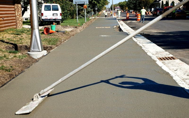 concrete-mixer-workman-finishes-and-smooths-concrete-surface-on-new-sidewalk