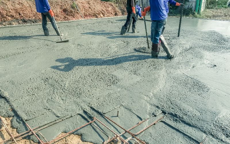 concrete-mixers-workers-using-a-wooden-spatula-for-cement-after-pouring-ready-mixed-concrete (1)