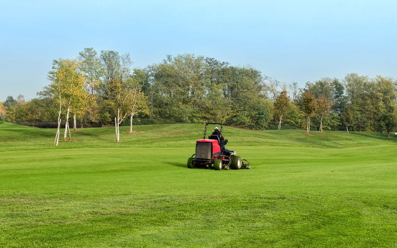 ride-on-mower-worker-moving-grass-on-golf-course