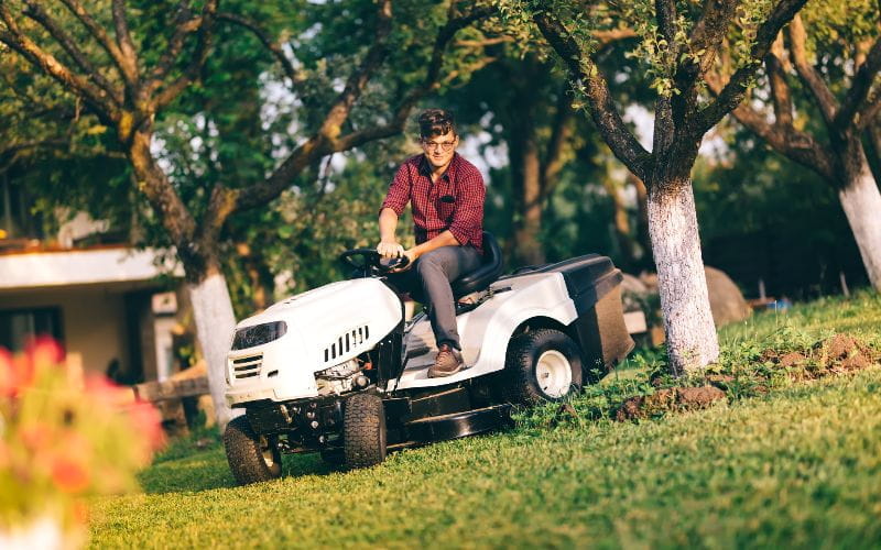 ride-on-mower-caring-lawncare-concept-handsome-young-man-trimming-grass-in-garden-using-tractor (1)