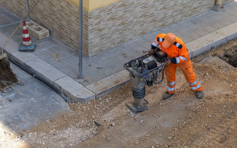 rammers-construction-worker-in-orange-safety-gear-operating-a-tamping-rammer-machine (1)
