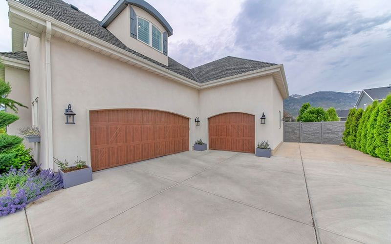 concrete-mixers-two-wooden-garage-doors-with-large-driveways-and-concrete-fence