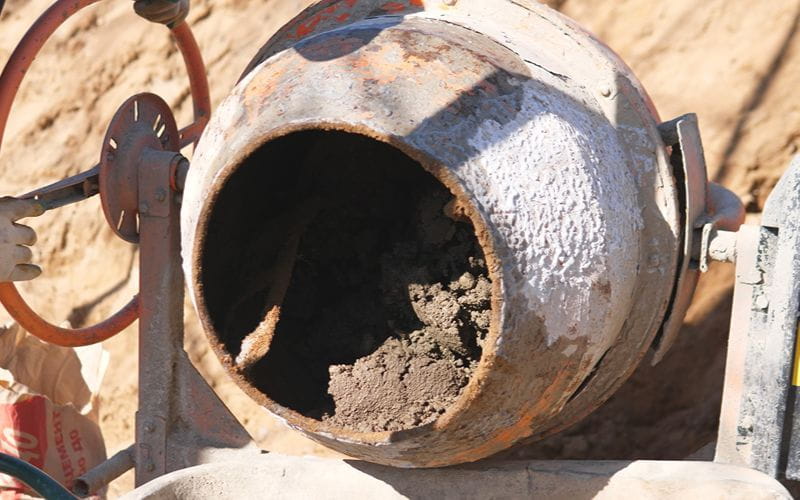 concrete-mixer-drum-with-dried-residue-and-rust-idle-equipment-and-maintenance-mood-on-house-construction-terrain