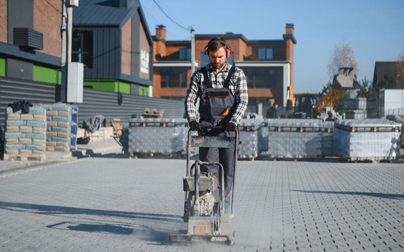 petrol-rammers-male-worker-using-vibratory-plate-compactor-to-firm-soil-at-worksite-builder-after-laying-of-paving-slabs-compacts (1)