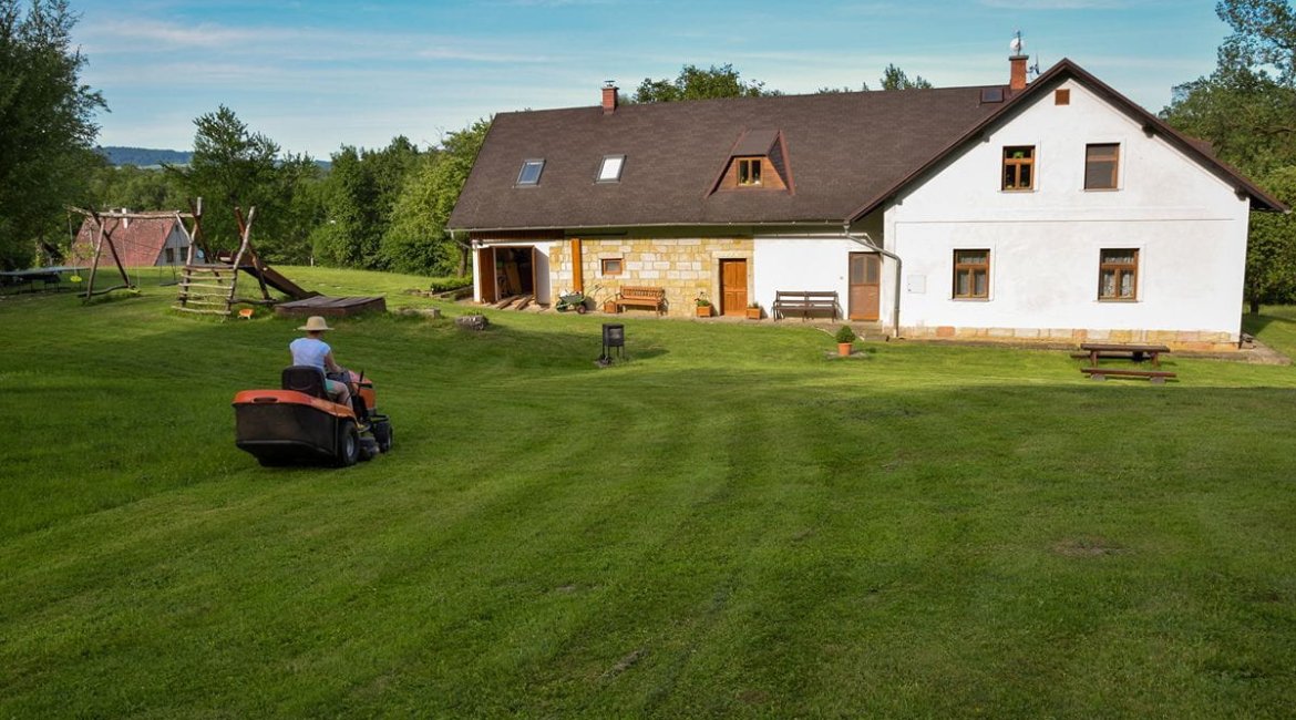ride-on-mower-female-gardener-driving-a-lawn-tractor-and-mowing-grass