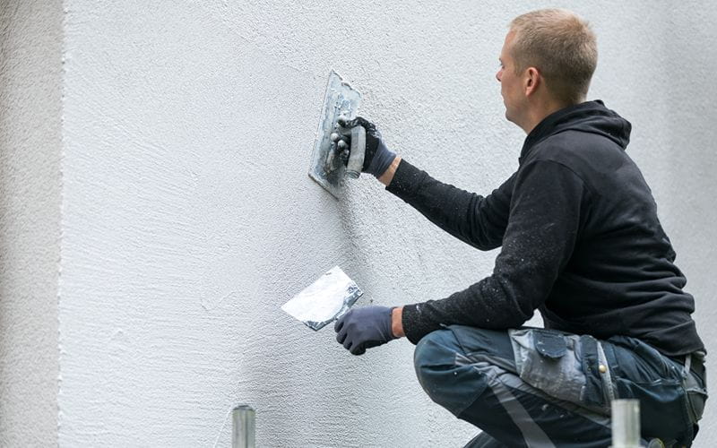 concrete-mixers-construction-worker-putting-decorative-plaster-on-house-exterior (1)